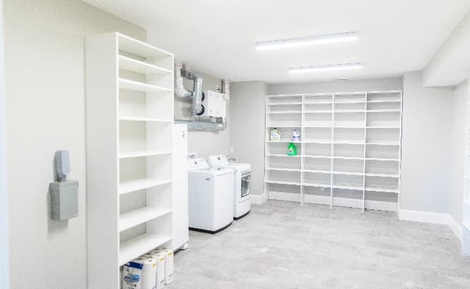 bright, white, light and large laundry room with shelves