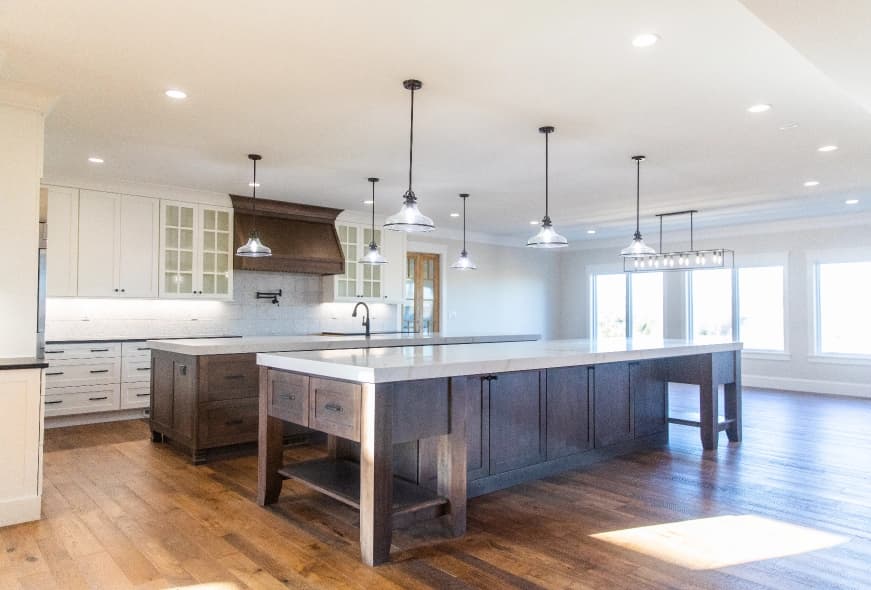 open and airy kitchen with island and lights hanging down from ceiling